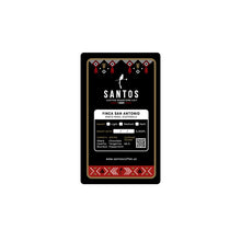 Load image into Gallery viewer, Close-up of Santos Coffee San Antonio label showing Medium roast, elevation 3,900 ft, and flavor notes of chocolate, tropical fruit, and peppermint.
